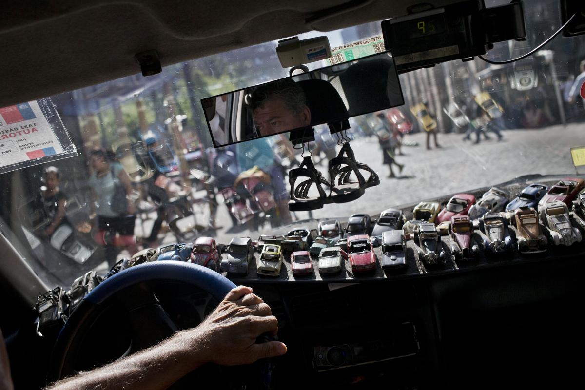 Xe mô hình được đặt kín trên táp-lô xe của tài xế taxi Roman Donoso khi anh đang chay trên các con phố ở trung tâm Santiago, Chile, 22/02/2016.