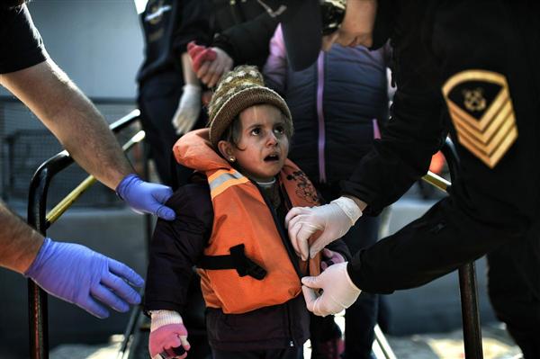 Một bé gái tỏ vẻ sợ sệt khi lực lượng bảo vệ bờ biển Hy Lạp gỡ áo phao lúc cô bé và những người nhập cư hay tị nạn đến cảng phía Bắc đảo Lesbos, Mytilene, sau khi vượt qua vùng biển Aegean từ Thổ Nhĩ Kỳ, 20/02/2016.