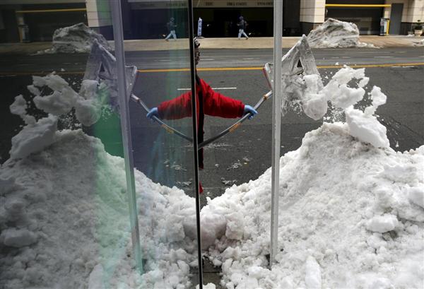 Một công nhân dọn tuyết tại một trạm xe buýt ở Washington, 26/01/2016.