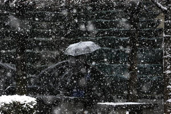 Tuyết rơi trên chiếc ô của một người đang đứng đợt xe buýt tại Pittsburgh, 09/02/2016.
