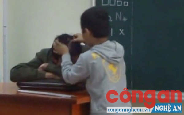Hình ảnh trò nhổ tóc bạc cho thầy gây tranh cãi ở huyện Quỳnh Lưu (Ảnh cắt từ clip)