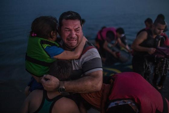  Laith Majid, một người tị nạn từ Iraq, bật khóc khi cùng con gái và con trai tới đảo Kos của Hy Lạp an toàn.