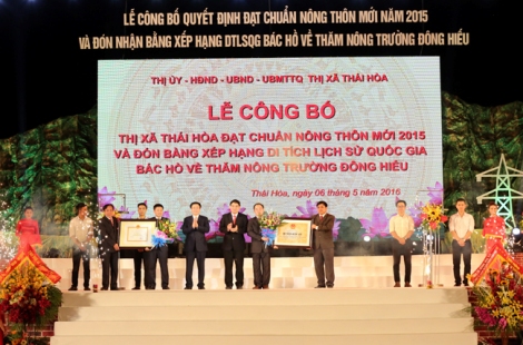Phó Thủ tướng Vương Đình Huệ trao danh hiệu “Huyện nông thôn mới” và Bằng Di tích lịch sử cấp quốc gia ghi dấu lần Bác Hồ về thăm nông trường Đông Hiếu. Ảnh: VGP/Thành Chung