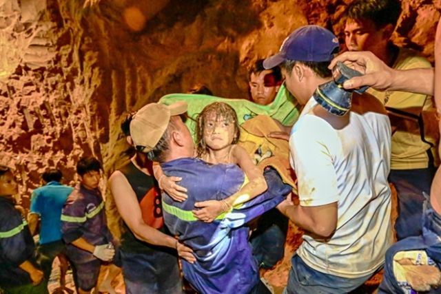 Bức ảnh ghi lại khoảnh khắc khoảnh khắc bé Nguyễn Trần Tú Anh (7 tuổi) được Cảnh sát PCCC&CNCH Bình Dương giải cứu khỏi lòng đất.