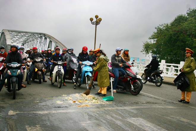 Hình ảnh Thiếu úy Nguyễn Thị Ái Vân và Thượng sỹ Phan Thị Bích Ngọc dọn dẹp trên đường.