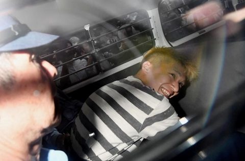 Satoshi Uematsu - kẻ cầm dao đâm chết 19 người ở một trung tâm dành cho người khuyết tật ở Nhật Bản hôm 26-7 cười man dại khi được áp giải lên xe của cảnh sát. Cuộc tấn công bằng dao này được đánh giá là cuộc tấn công thảm khốc nhất tại Nhật kể từ sau Thế chiến thứ hai - Ảnh: Reuters