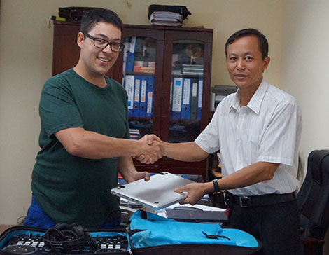 Thượng tá Ngô Văn Đáp (bên phải) trao trả tài sản bị mất trộm cho công dân nước ngoài.