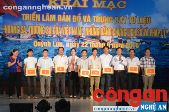 Đại diện lãnh đạo HĐND tỉnh và huyện Quỳnh Lưu trao cờ Tổ quốc cho các ngư dân