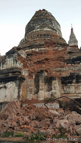 Một ngôi chùa cổ bị tàn phá nặng nề, gạch đá rơi đầy xuống đất. Ảnh: Tân Hoa xã