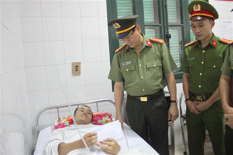 Đồng chí Đại tá Nguyễn Hữu Cầu, Giám đốc Công an tỉnh Nghệ An hỏi thăm, động viên Trung úy Lê Văn Tuấn