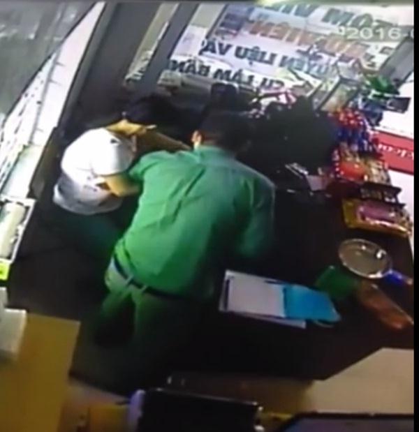 Hình ảnh từ camera ghi lại người đàn ông áo xanh lấy tiền của chị H tại siêu thị mini.
