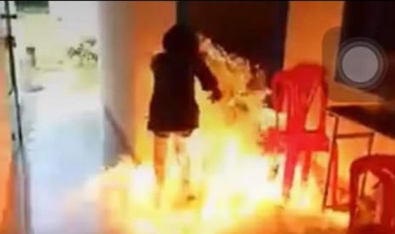 Em Trần Ngọc T. bị bỏng do tự mình dùng xăng đốt trường (Ảnh cắt từ clip)