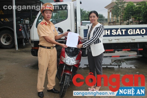 Đại diện đội CSGT Công an TP trao trả lại chiếc xe máy cho chị Miên