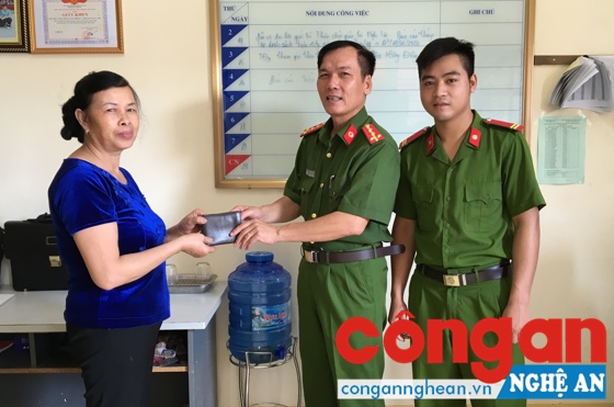 Đại diện chỉ huy đội và chiến sỹ Nguyễn Kim Danh trao trả lại tài sản cho gia đình ông Trần Đình Đức