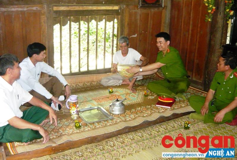 Đội Xây dựng phong trào và phụ trách xã về ANTT Công an huyện Quỳ Hợp tặng quà cho già làng Mạc Văn Phương ở bản Nguông, xã Châu Cường
