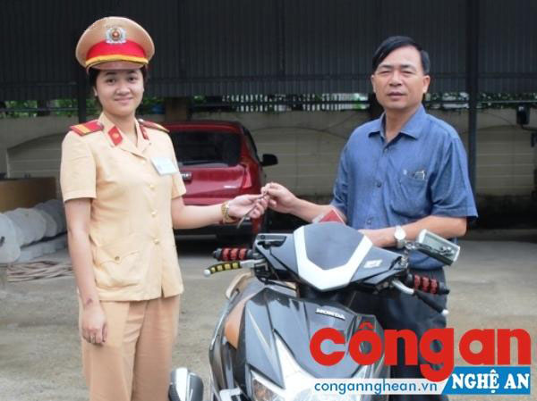 Cán bộ Đội CSGT Công an TP Vinh trao trả xe máy bị mất cho đại diện gia đình chị Tâm