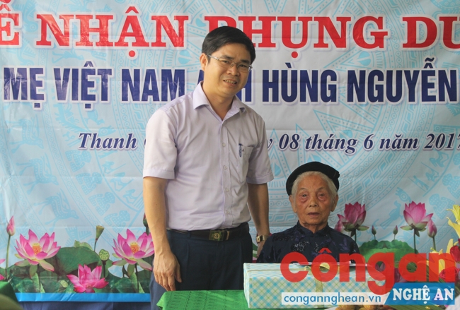 Đại diện lãnh đạo UBND huyện Thanh Chương tặng quà cho mẹ Nguyễn Thị Năm
