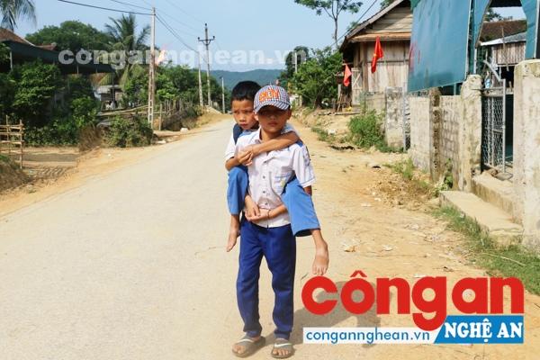 Cậu bé Vi Văn Khanh đang cõng người bạn tật nguyền của mình đến trường