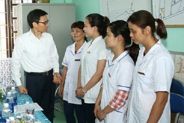 Phó Thủ tướng Vũ Đức Đam trò chuyện với các cán bộ trạm y tế xã Điền Thắng Trung. Ảnh: VGP/Đình Nam