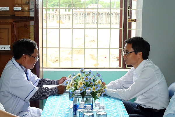Phó Thủ tướng Vũ Đức Đam trò chuyện với trạm trưởng trạm y tế xã Điền Thắng Trung Lê Tự Hồ. Ảnh: VGP/Đình Nam