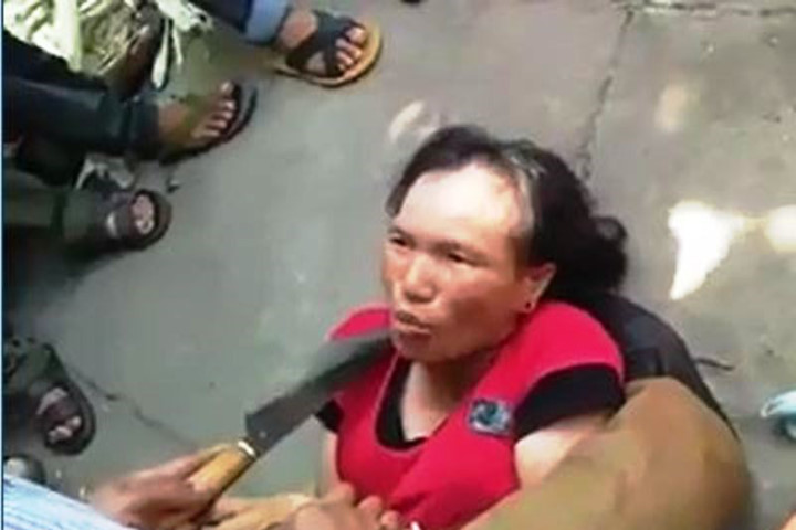 Người phụ nữ bị nghi bắt cóc trẻ em bị người dân dí dao vào cổ (Ảnh cắt từ clip)