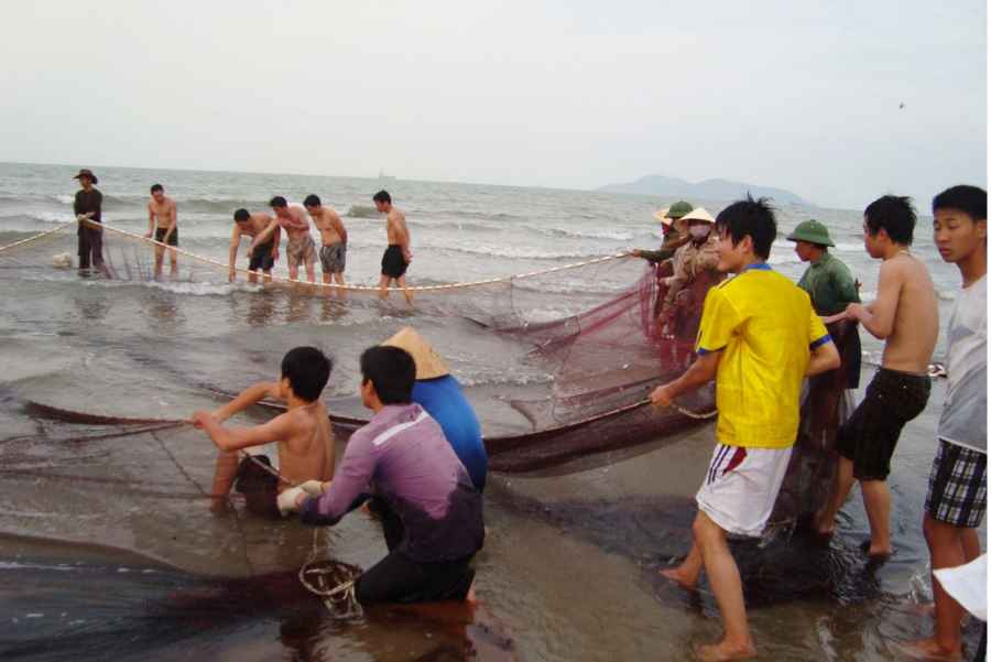 Du khách tham gia kéo lưới gần bờ với ngư dân tại bãi biển Cửa Hội. Ảnh: Bình Nguyên