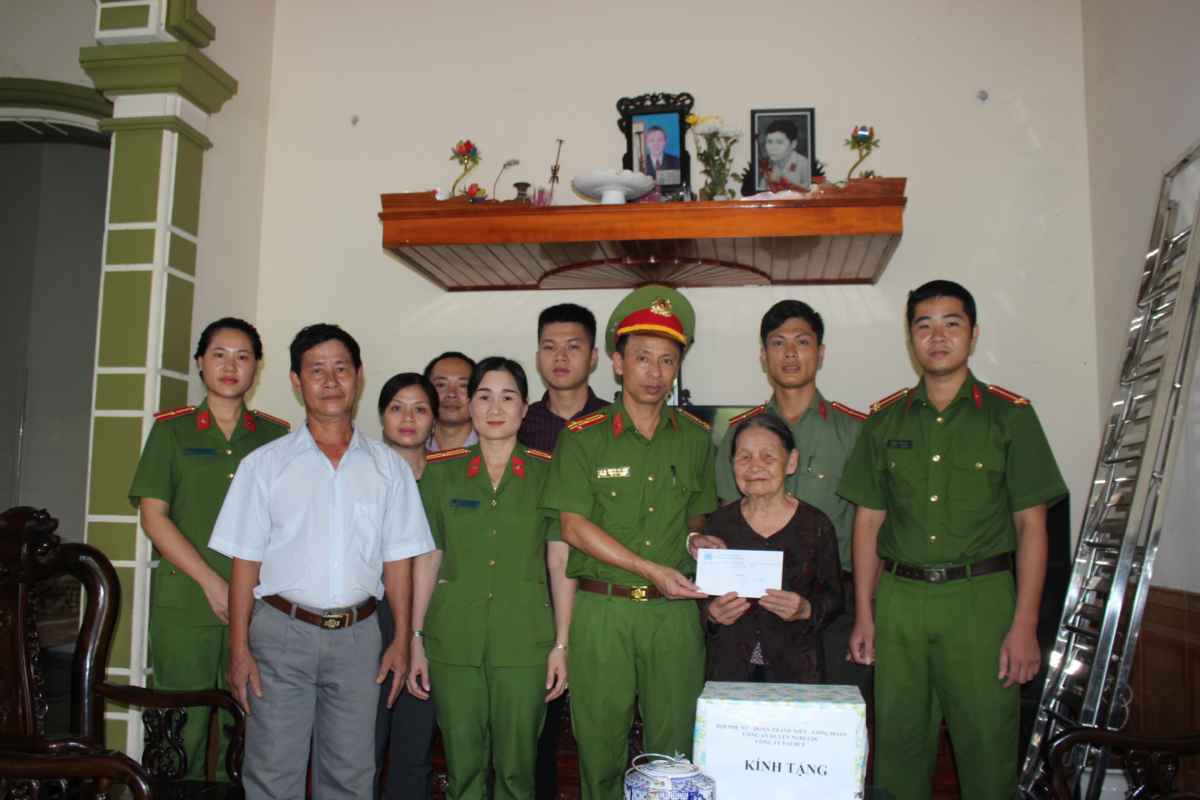 Cán bộ, chiến sỹ Công an huyện Nghi Lộc và đại diện Công ty Đại Huệ thăm, tặng quà bà Trần Thị Phùng - mẹ liệt sỹ ở xóm 5 xã Phúc Thọ.