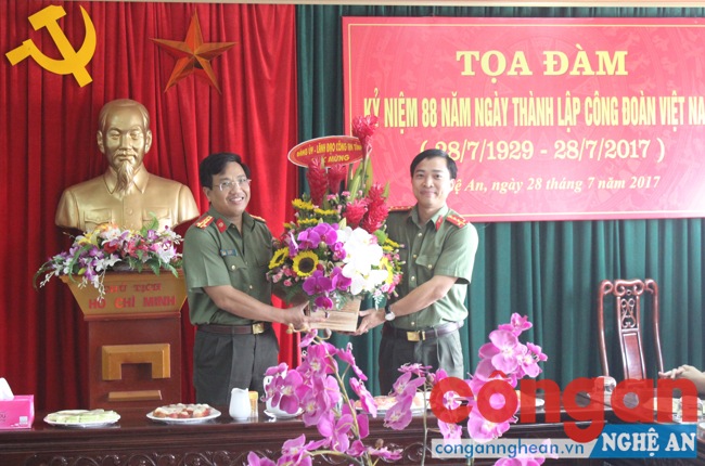 Đại diện Ban giám đốc Công an tỉnh, đồng chí Hồ Văn Tứ tặng lẵng hoa tươi thắm cho Công đoàn Công an tỉnh