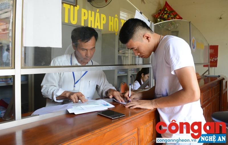 Cán bộ, công chức hướng dẫn người dân giải quyết thủ tục hành chính tại “Bộ phận một cửa” của UBND thị trấn Con Cuông