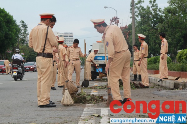 Các bộ, chiến sĩ đội CSGT Công an TP Vinh thu dọn vệ sinh sau bão
