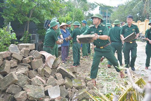 BĐBP phường Nghi Hải, thị xã Cửa Lò giúp dân dọn dẹp, sửa sang nhà cửa. Ảnh: Báo Nghệ An