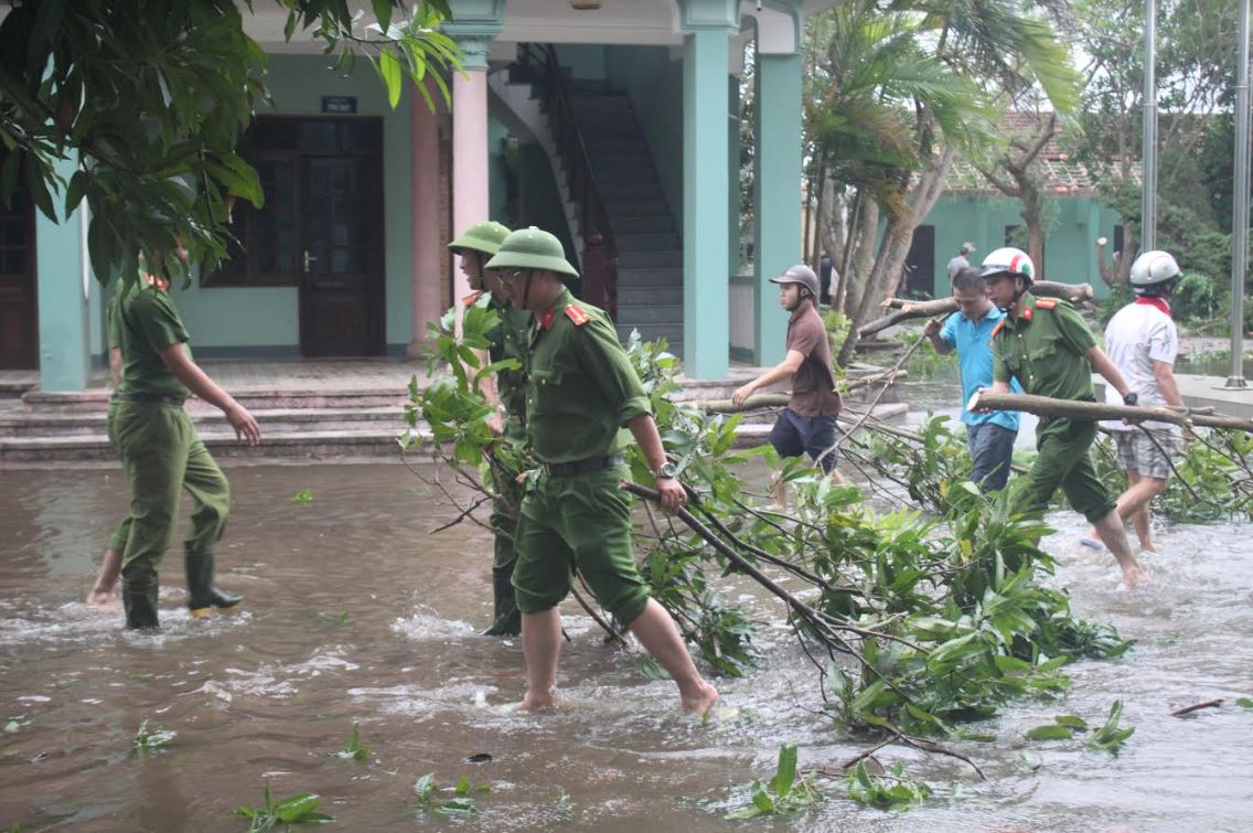 Công an huyện Quỳnh Lưu giúp dân dọn dẹp sau bão. Ảnh: Mạnh Cường