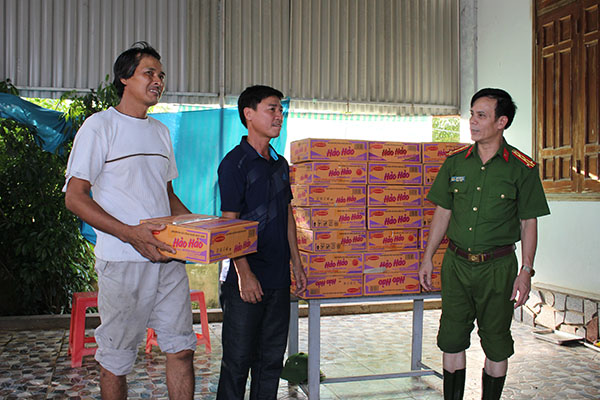 Đồng chí Đại tá Trần Ngọc Tú, Trưởng Công an TP Vinh trao hàng cứu trợ cần thiết đến các hộ dân bị ngập lụt nghiêm trọng.