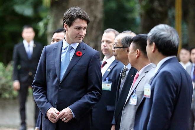 Thủ tướng Trudeau thích thú dạo bộ trong khuôn viên khu di tích Chủ tịch Hồ Chí Minh tại Phủ Chủ tịch. (ảnh: Dân Việt)