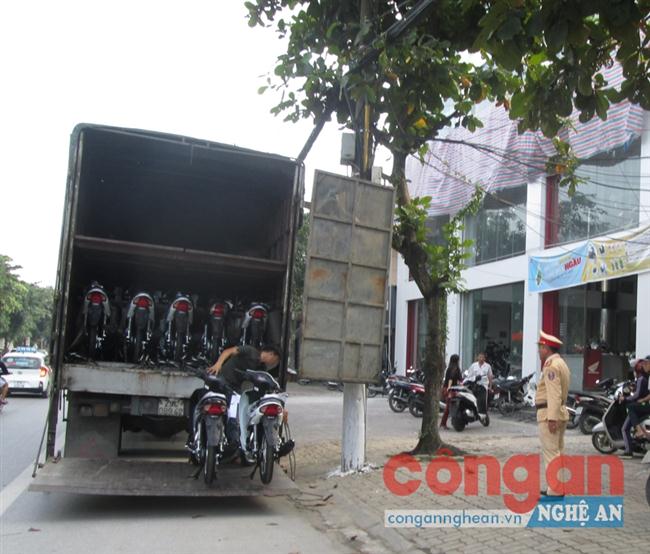 Xe ô tô tải đang bốc hàng xuống cửa hàng xe máy Kim Dung trên đường Nguyễn Văn Cừ