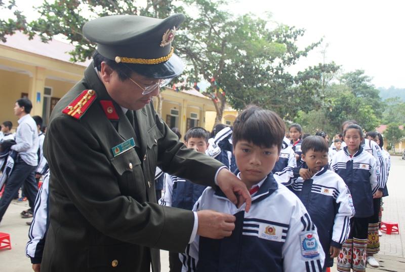 Đồng chí Đại tá Hồ Văn Tứ, Phó Giám đốc Công an tỉnh Nghệ An tặng áo cho các em.