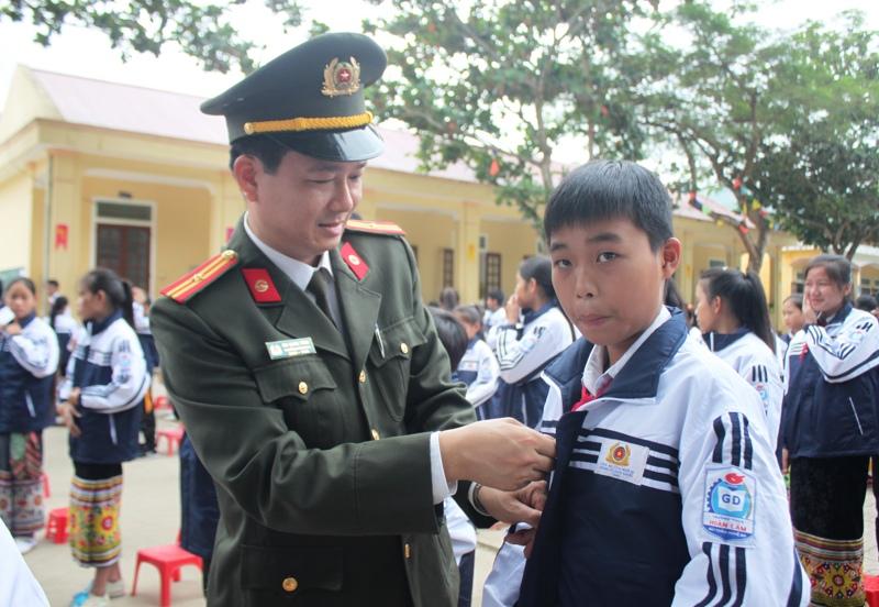 Lãnh đạo Phòng tổ chức cán bộ Công an tỉnh Nghệ An tặng áo cho các em.