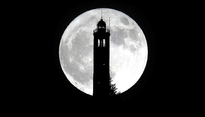 Siêu trăng trên ngọn hải đăng ở San Maurizio, Italy. Ảnh: EPA