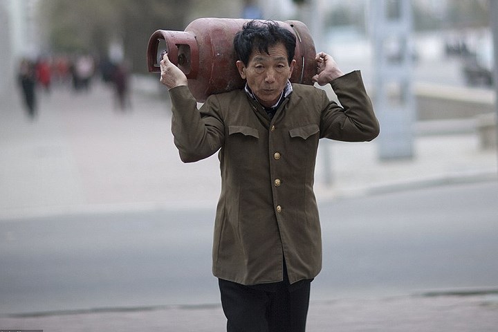 Người đàn ông Triều Tiên vác một bình gas trên phố. Loạt ảnh này được chụp vào năm 2014
