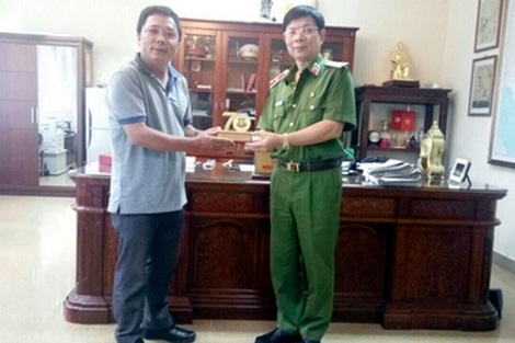 Thiếu tướng Nguyễn Dĩnh (bên phải), Cục trưởng Cục Cảnh sát truy nã tội phạm, trao tặng kỷ niệm chương cho Thiếu tá Lê Hữu Tuyến.