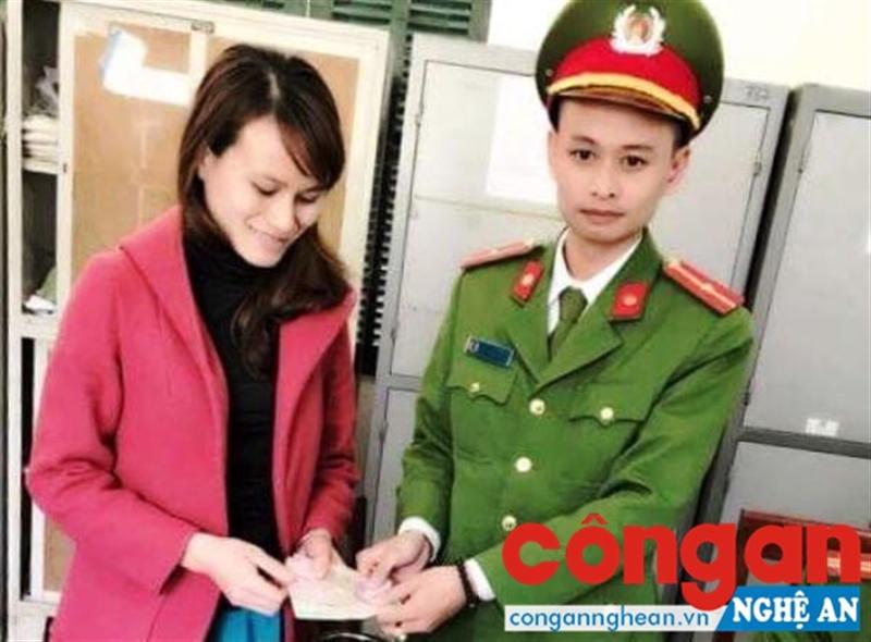 Thiếu úy Nguyễn Văn Lập, cán bộ Đội Điều tra Tổng hợp trao số tài sản bị mất trộm cho cô giáo Lữ Thị Nhung