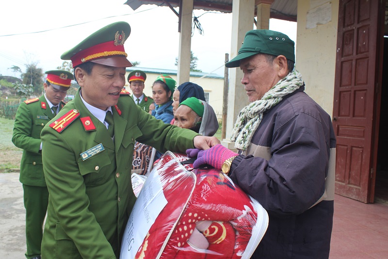 Thượng tá Trần Phúc Thịnh, Trưởng phòng CSMT trao quà cho các gia đình có hoàn cảnh khó khăn ở bản Tà Pàn, xã Tri Lễ, Quế Phong