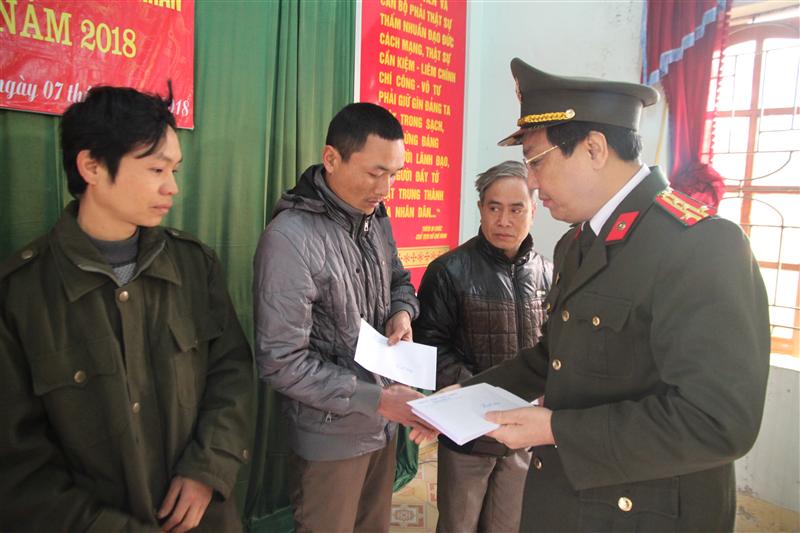 Đồng chí Đại tá Hồ Văn Tứ - Phó Giám đốc Công an tỉnh trao quà cho bà con xã Châu Hoàn