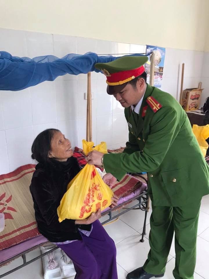 Trung tá Đào Văn Khôi, Phó trưởng Công an thị xã trao quà Tết đến cho bệnh nhân phong