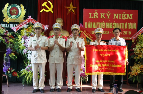 Đồng chí Nguyễn Đình Hòa, Tỉnh ủy viên, Bí thư Thị ủy thừa ủy quyền của lãnh đạo UBND tỉnh trao tặng bức trướng cho Công an TX Thái Hòa