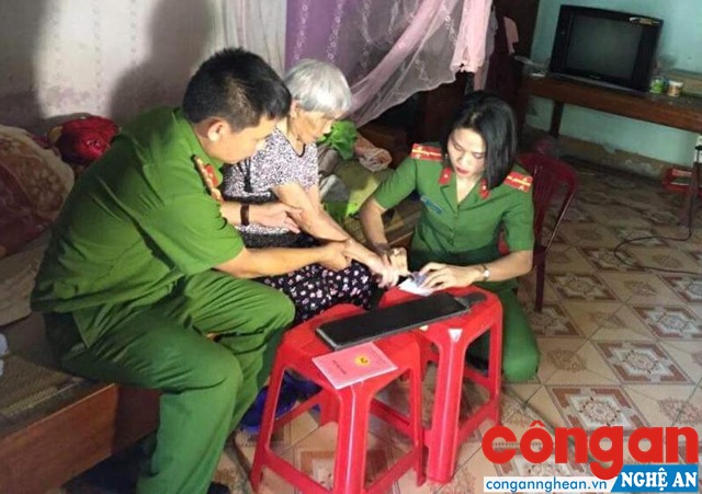 Cán bộ Đội Cảnh sát QLHC về TTXH Công an huyện Thanh Chương đến tận nhà làm thủ tục cấp CMND cho người già ở xã Ngọc Lâm 