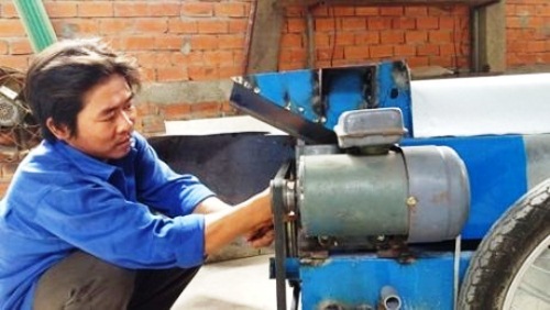 Anh Trần Huỳnh Long bên sản phẩm máy rửa trái hồng xiêm do mình sáng chế.