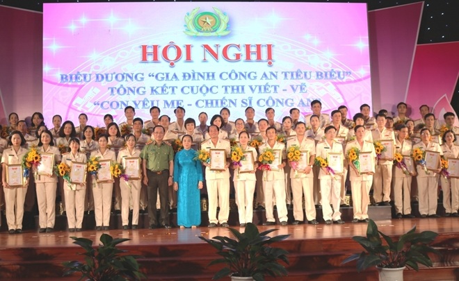 Thứ trưởng Nguyễn Văn Thành và bà Hoàng Thị Ái Nhiên trao thưởng và chụp ảnh lưu niệm với các gia đình Công an tiêu biểu.