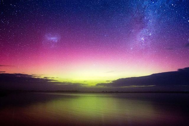 Cực quang với hồng tím với chút ánh sáng xanh lục ở chân trời, cùng hai đám mây Magellan là hai thiên hà vệ tinh của Ngân Hà, đang cùng tỏa sáng trên bầu trời bang Victoria, nước Úc. Ảnh: Getty Images.