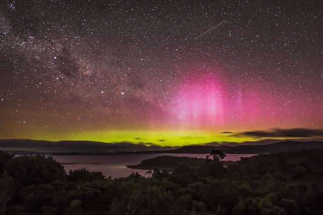 Cực quang ở Tasmania, Australia cùng một vệt sao băng vút nhanh qua bầu trời. Ảnh: Robert Downie/Getty Images.